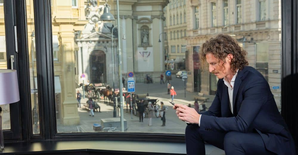 Person die nach Grundstücken in Wien auf seinem Handy sucht. 