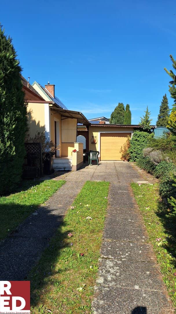 Single family home with garden and garage at the forest edge