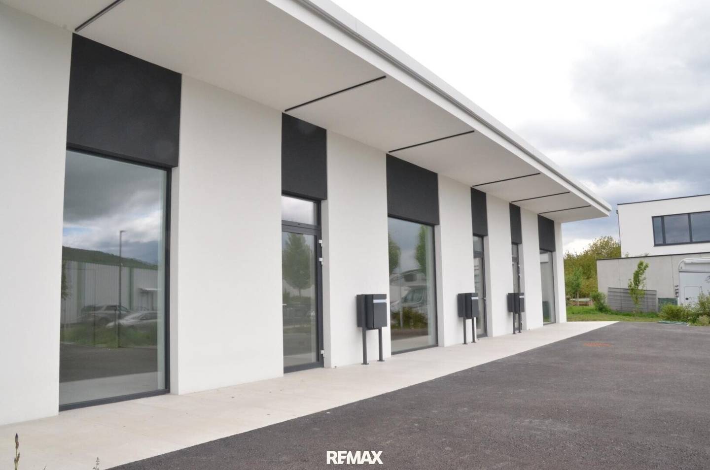 Modern commercial unit with parking spaces and heat pump