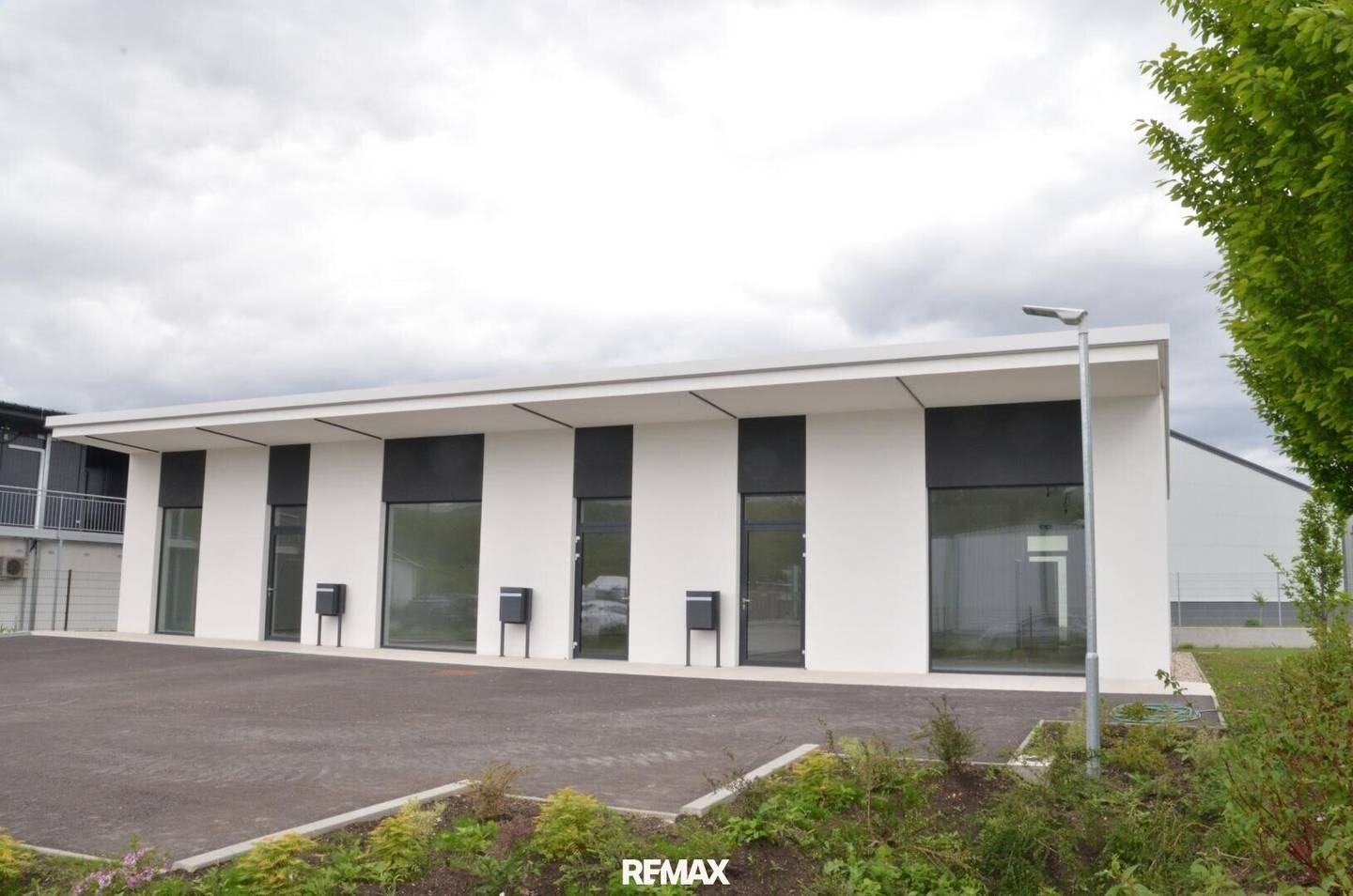 Modern commercial unit with parking spaces and heat pump