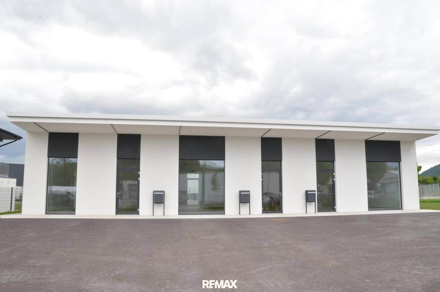 Modern commercial unit with parking spaces and heat pump
