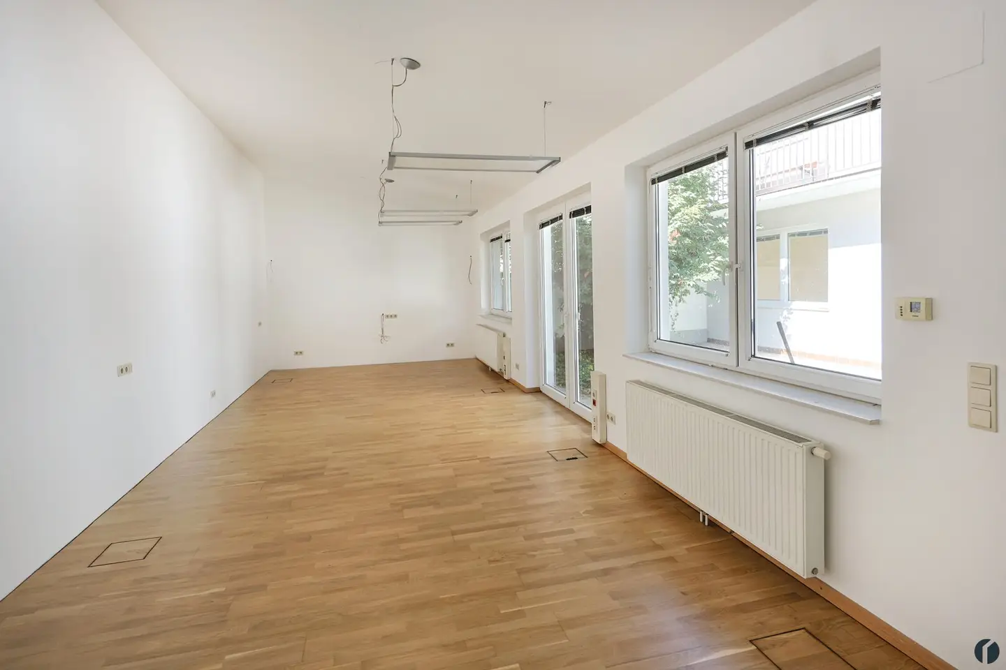 Helle Bürofläche mit Parkett und Klimaanlage im Innenhof
