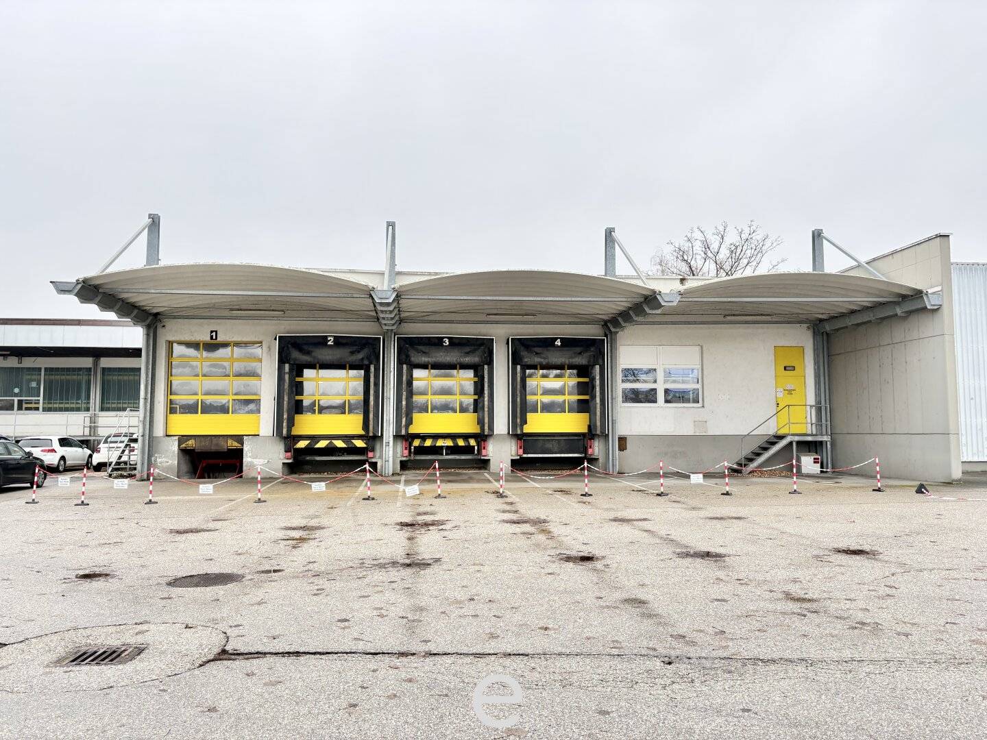 Warehouse with loading ramps and modern office space in industrial area