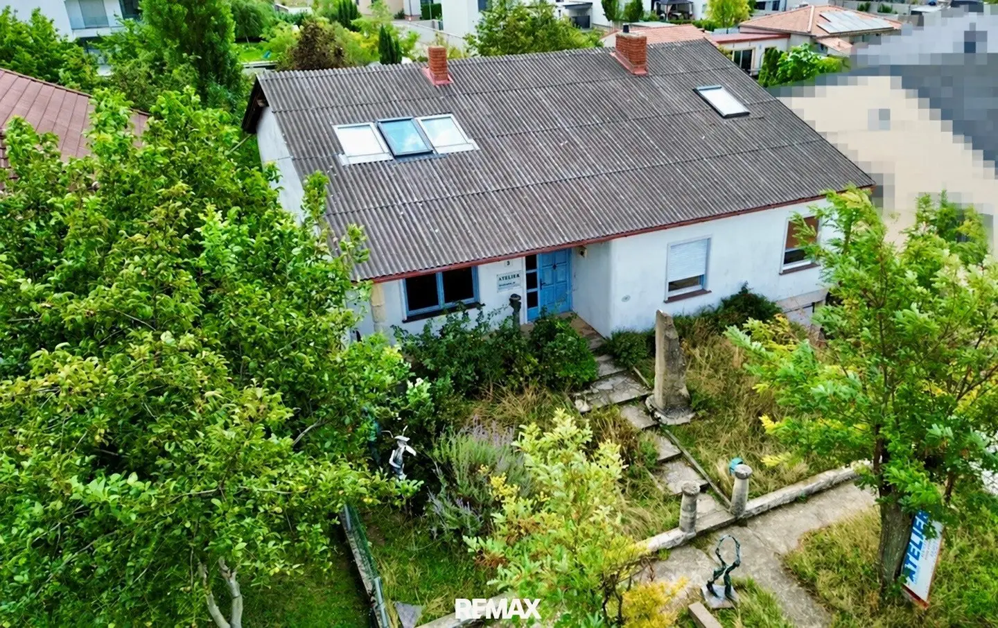 Ort der Kreativität - Ein Haus umgeben von Sandstein und viel Grün.