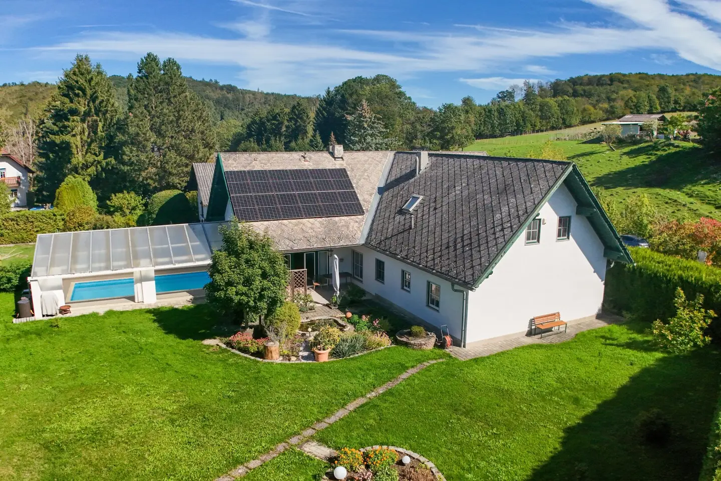 Sommer im eigenen Garten mit Pool, Kaminfeuer im Winter – ein Haus fürs ganze Jahr