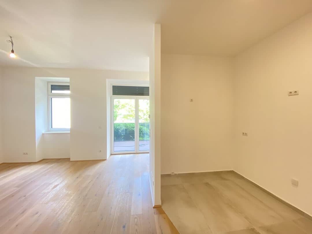 Wohnesszimmer mit Nische für Küche und Zugang zur Terrasse